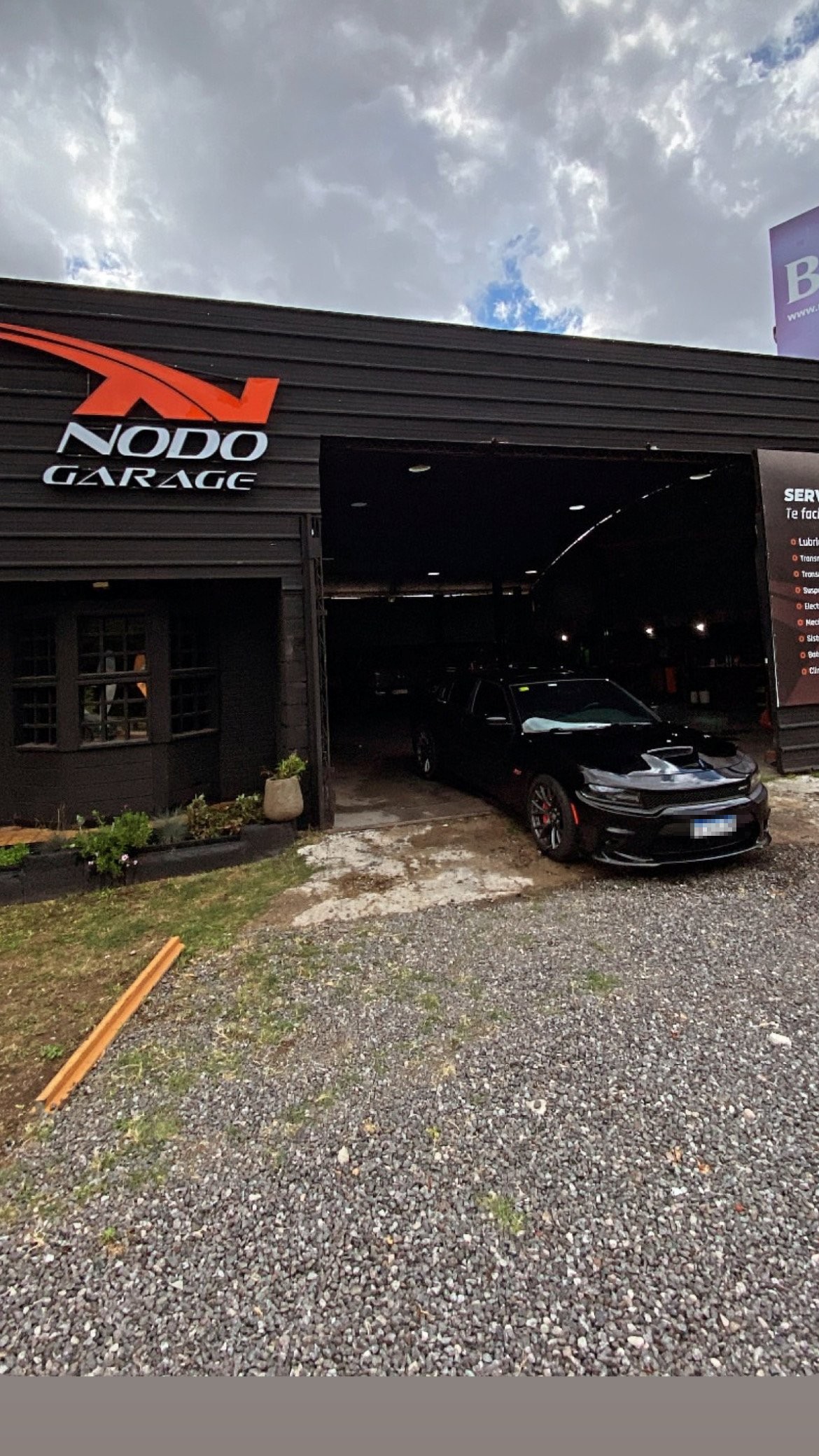 Ingreso a Nodo Garage con cartel iluminado, Av. Intendente Mestre, Córdoba