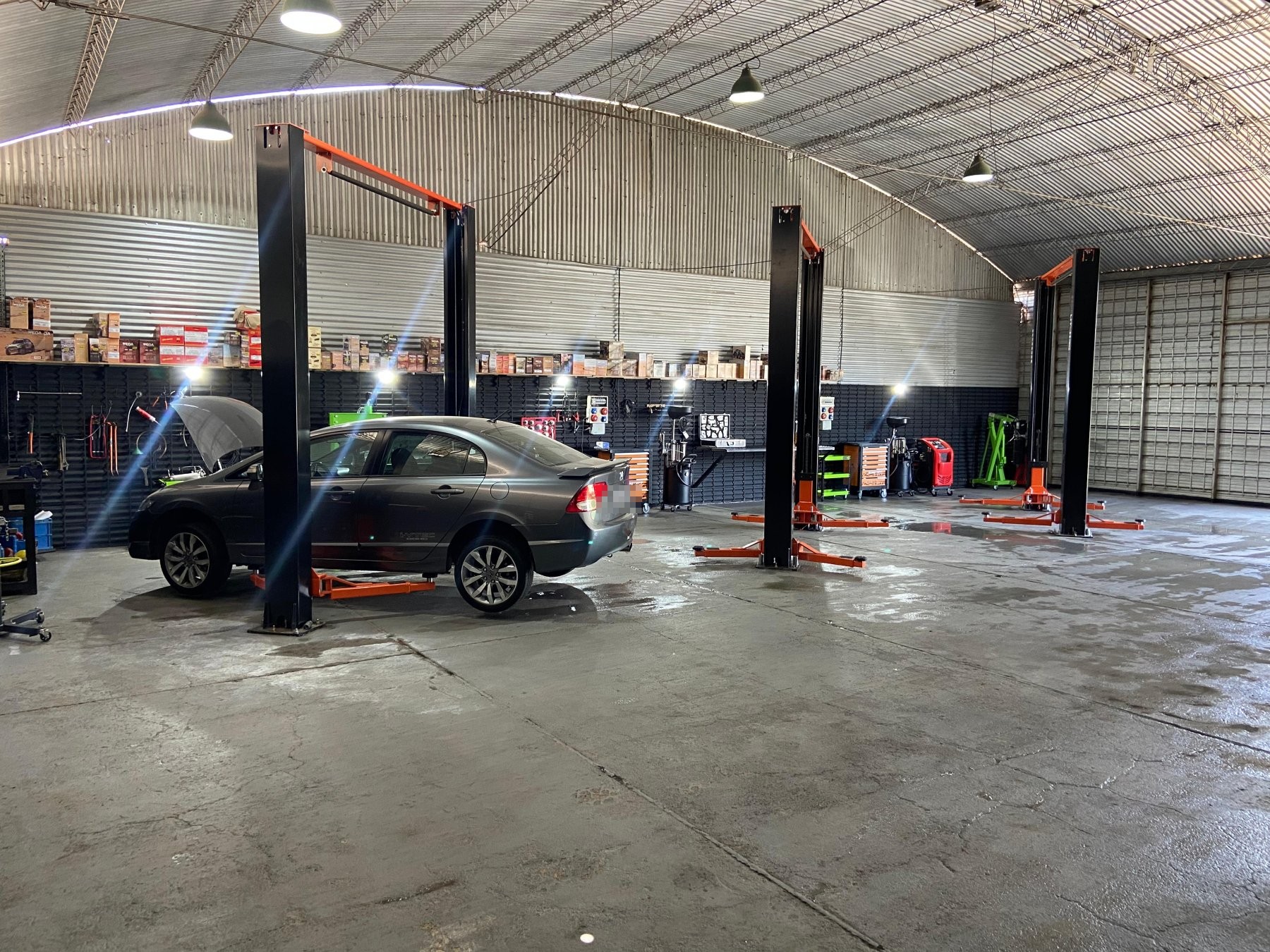 Auto en elevador durante un trabajo de mecánica general en Nodo Garage, Córdoba